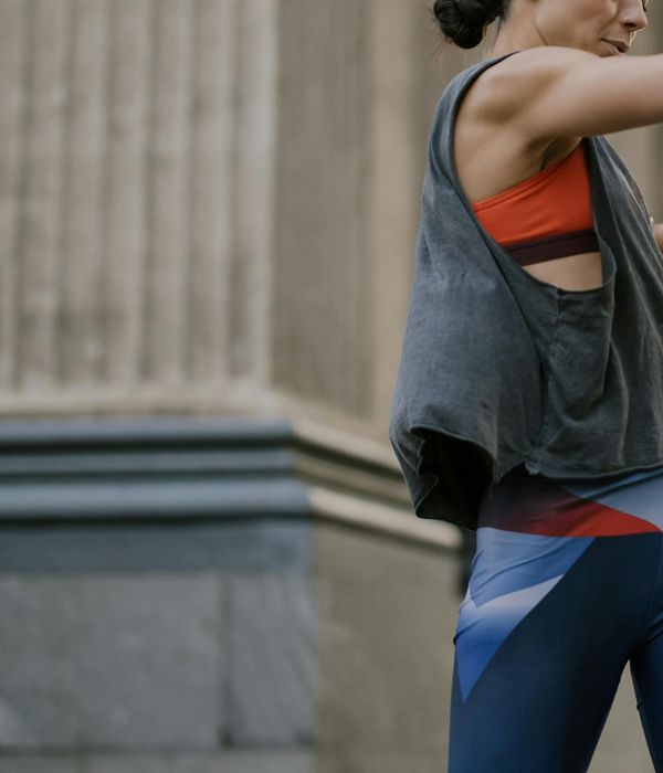 Woman in activewear performing a dynamic cardio movement with a focused expression.